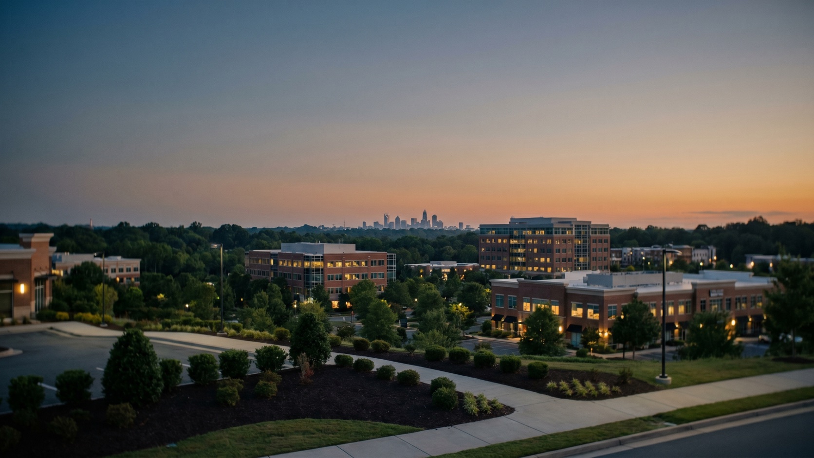 Elevated dusk view of the SouthPark commercial district rising above Charlotte's dense tree canopy